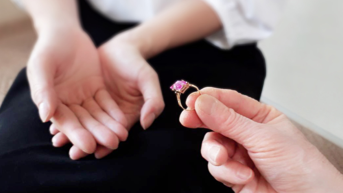 高齢者が女性に指輪を渡す